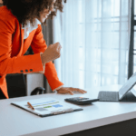Confident Black women looking at laptop; Salary negotiation tips for Black women Salary negotiation strategies for professional Black women How to negotiate a higher salary for Black women Salary negotiation coaching for Black female executives