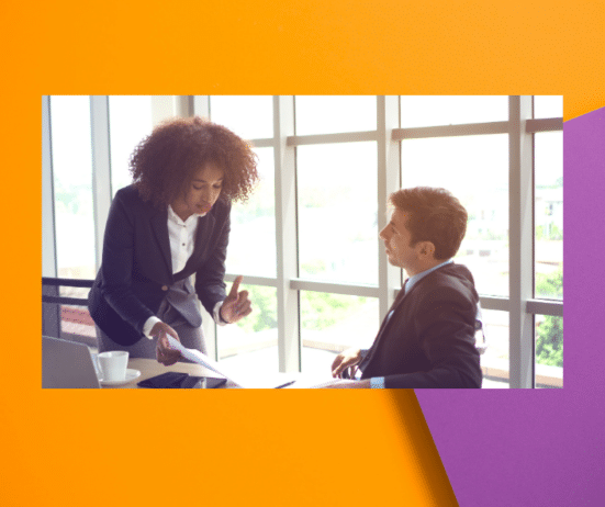 a man and woman talking in front of a window; Coaching-for-dealing-with-workplace-sabotage