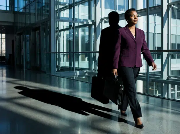 Black woman walking carrying brief case; what is executive presence