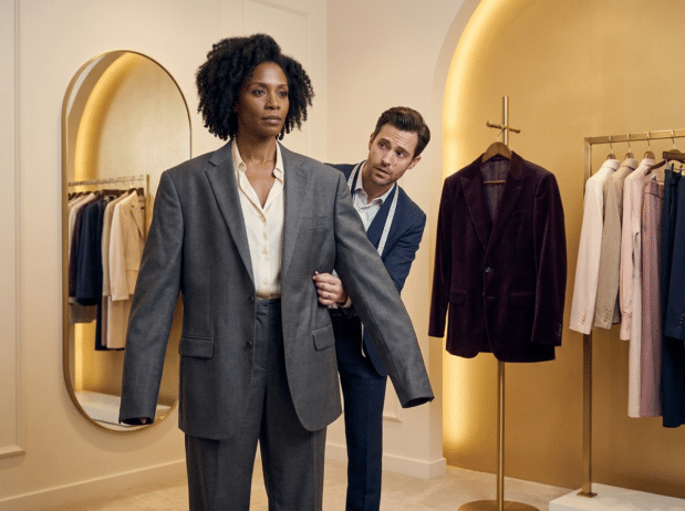 Black woman being fitted with an ill fitted suit; Executive Coaching That Actually Fits Black Women Now